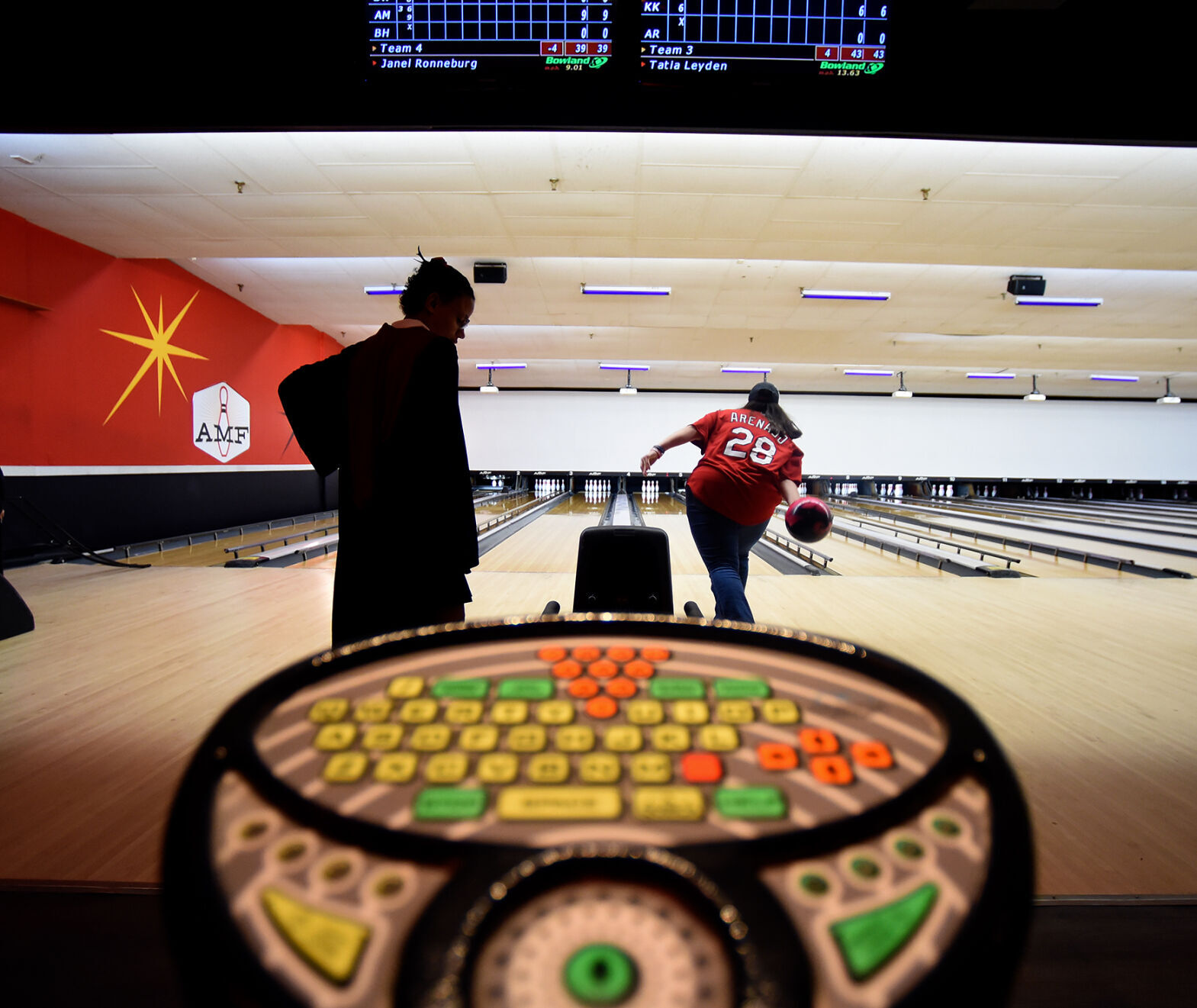 Jannel Ronneburg, left, waits for a ball as Tatia Leyden throws her bowling ball